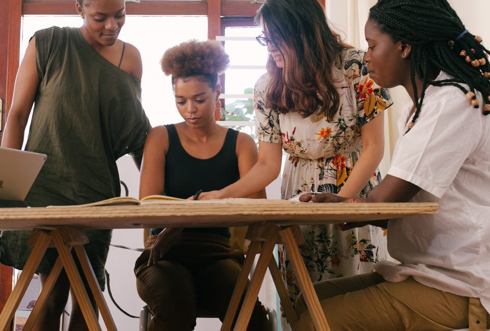 Four African-American women discussing leadership. Leadership coaching for women.