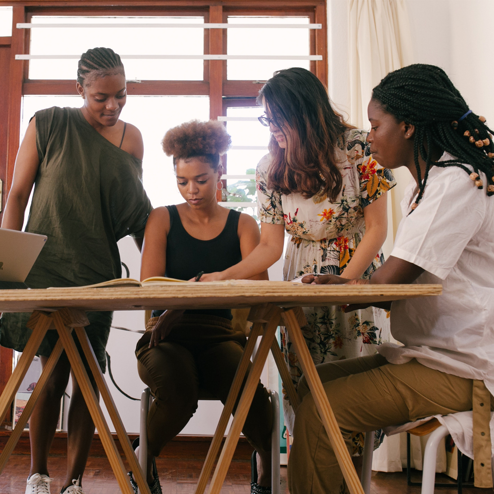 Four African-American women discussing leadership. Leadership coaching for women.